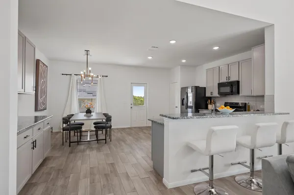 a kitchen with stainless steel appliances kitchen island granite countertop a refrigerator and a stove top oven