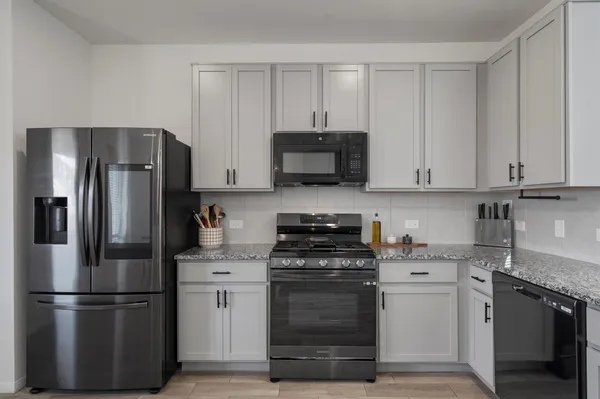 a kitchen with stainless steel appliances granite countertop a refrigerator stove and sink with granite countertops