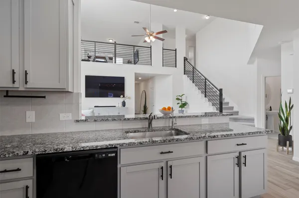 a kitchen with stainless steel appliances granite countertop a sink and a white cabinets