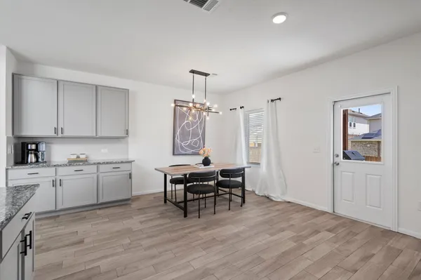 a kitchen with granite countertop cabinets dining table and chairs