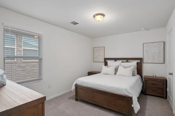 a bedroom with a bed and a night stand