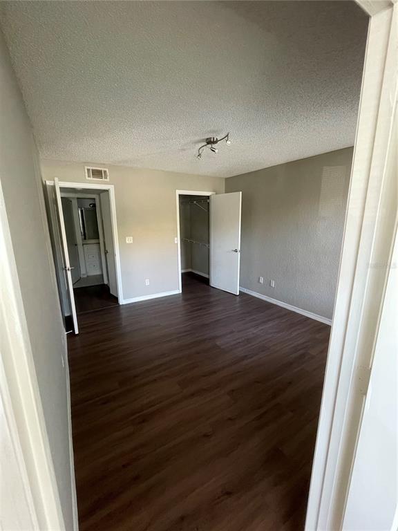 5148 Conroy Road, Unit 1214 Orlando, FL 32811 - Photo 12 of 16 an empty room with wooden floor and mirror