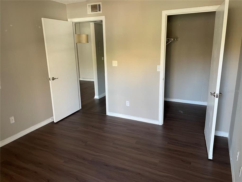5148 Conroy Road, Unit 1214 Orlando, FL 32811 - Photo 13 of 16 an empty room with wooden floor and entrance