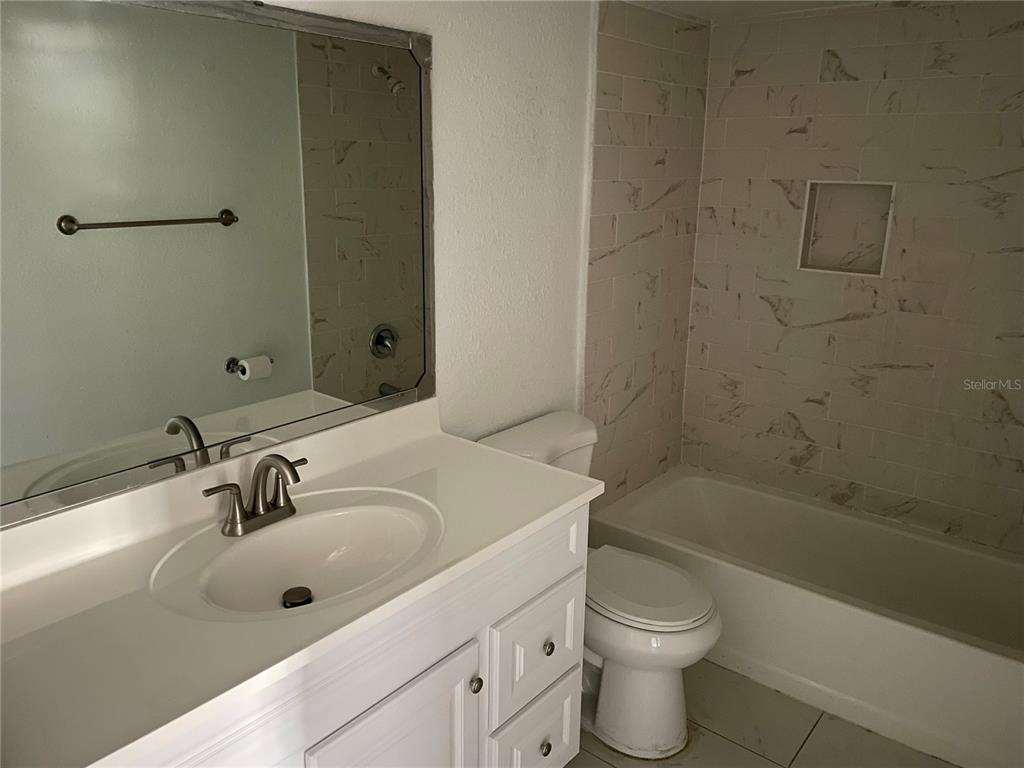 5148 Conroy Road, Unit 1214 Orlando, FL 32811 - Photo 15 of 16 a bathroom with a sink a toilet and shower