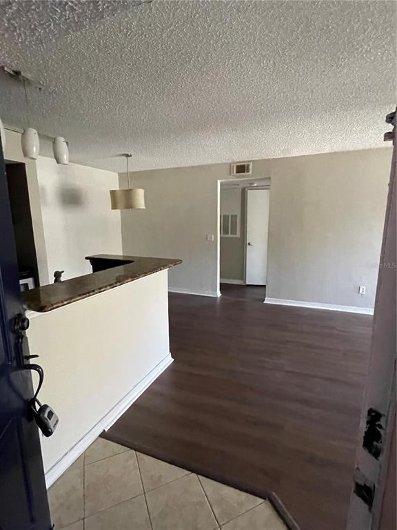 5148 Conroy Road, Unit 1214 Orlando, FL 32811 - Photo 3 of 16 a view of a kitchen with refrigerator and wooden floor