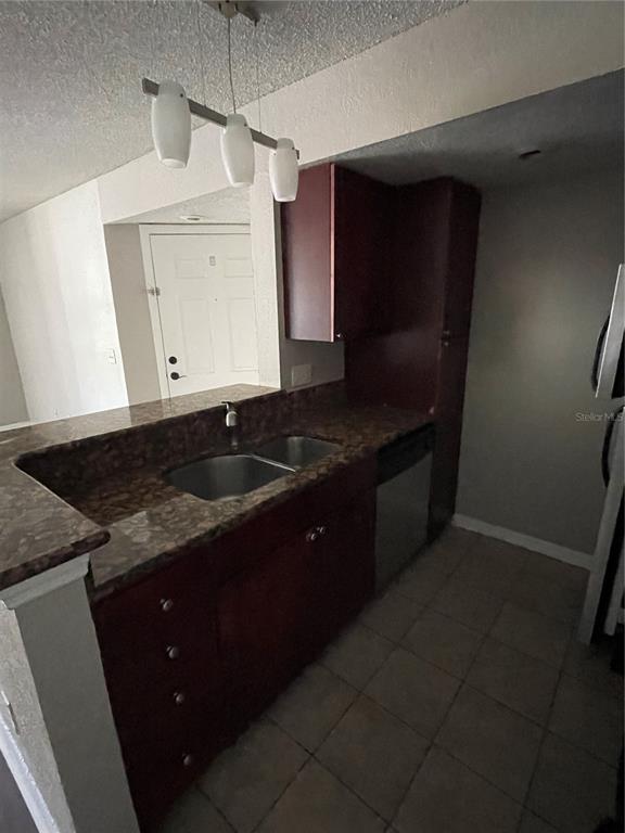 5148 Conroy Road, Unit 1214 Orlando, FL 32811 - Photo 5 of 16 a kitchen with a sink a stove and cabinets