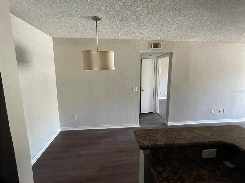 5148 Conroy Road, Unit 1214 Orlando, FL 32811 - Photo 6 of 16 a room with wooden floor and potted plant
