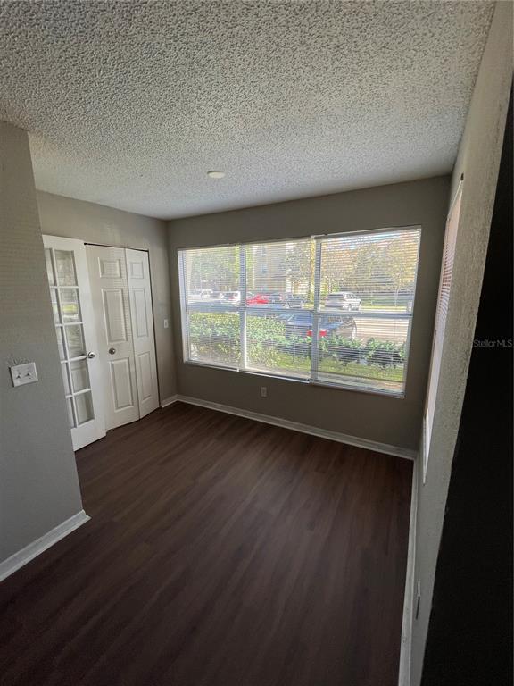 5148 Conroy Road, Unit 1214 Orlando, FL 32811 - Photo 9 of 16 an empty room with wooden floor and windows