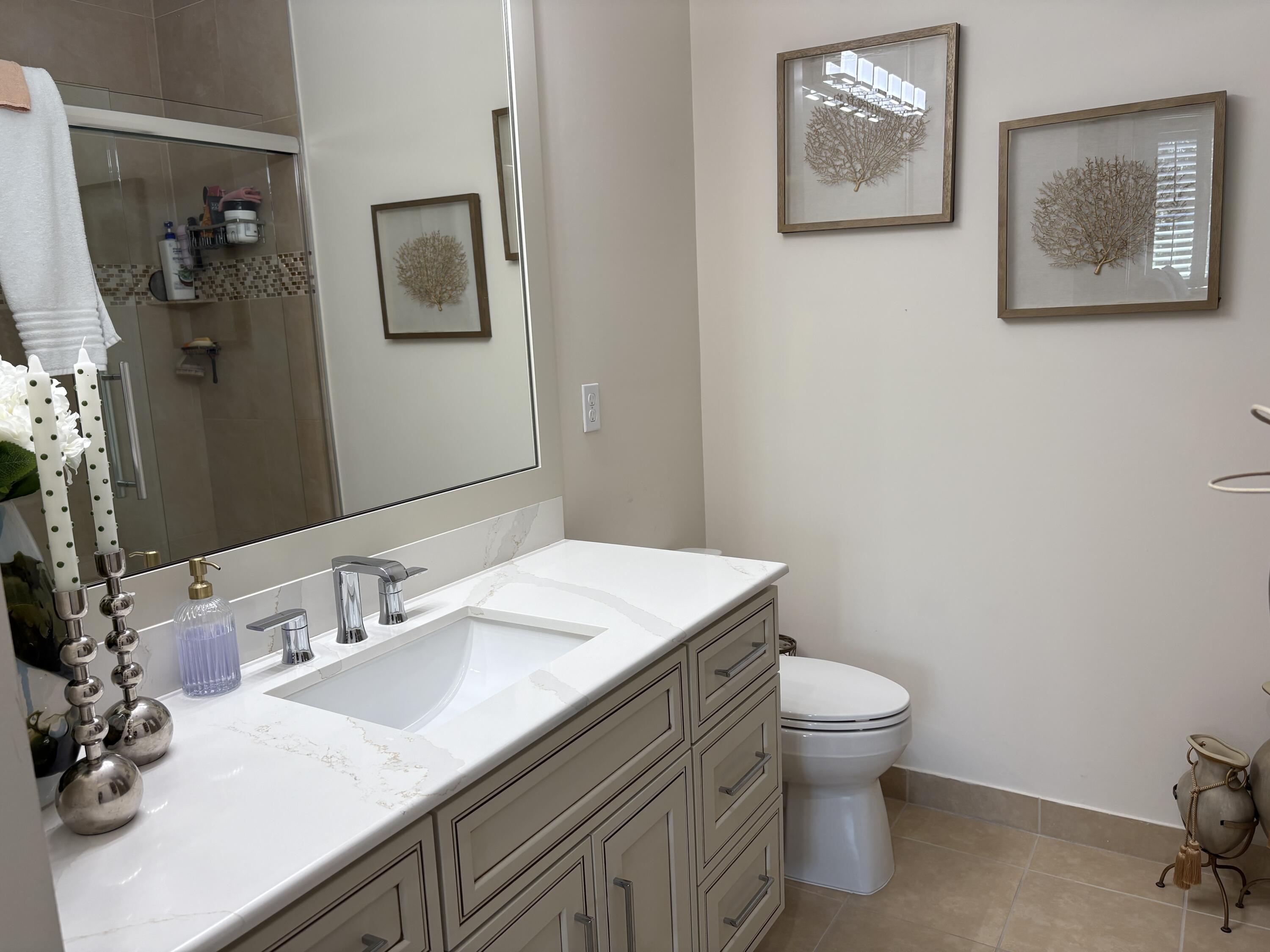 344 Lake Monterey Circle Boynton Beach, FL 33426 - Photo 11 of 14 a bathroom with a toilet sink and mirror