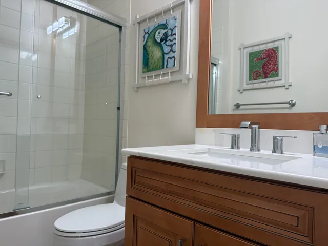 a bathroom with a granite countertop sink a toilet and shower