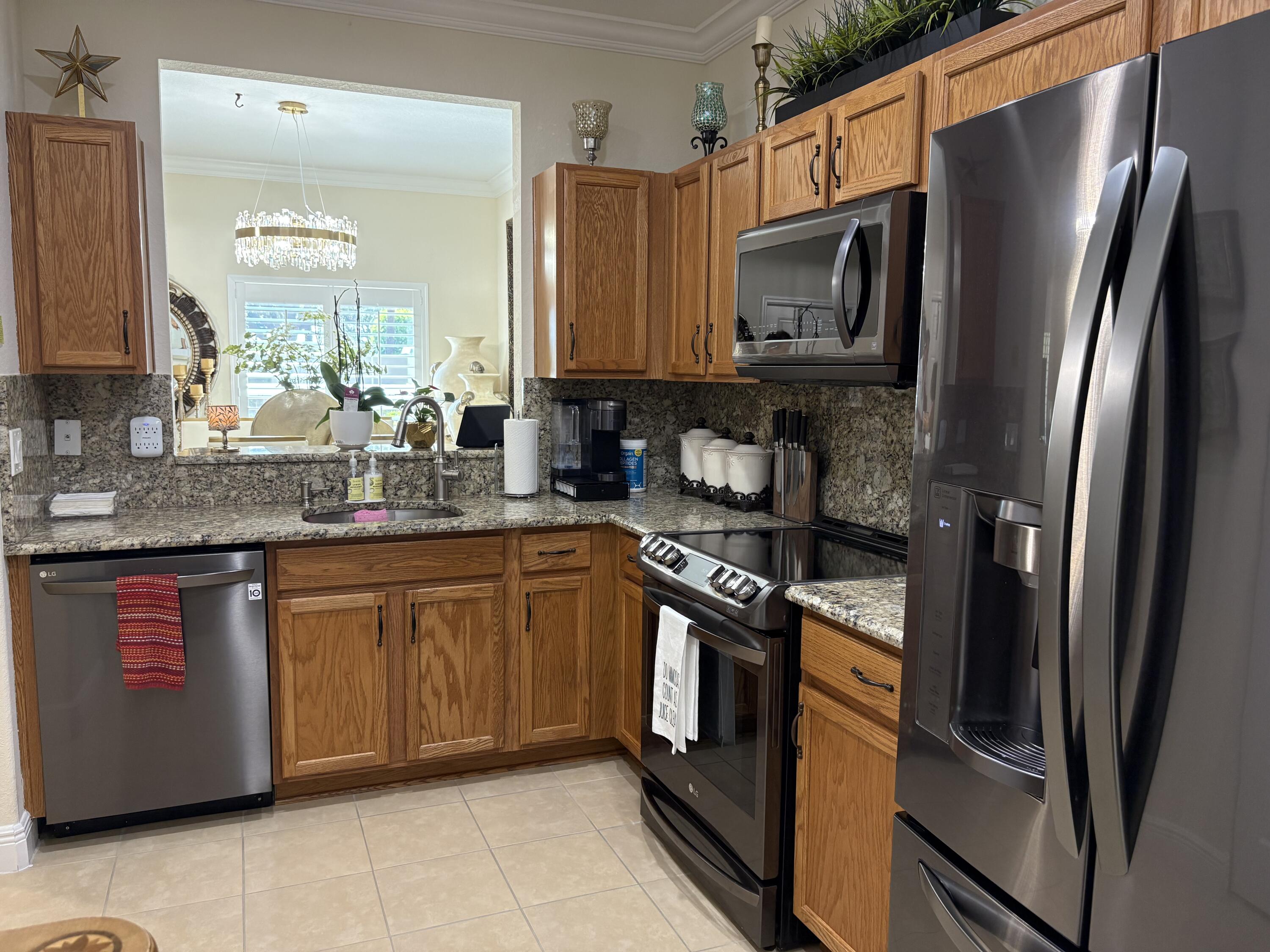 344 Lake Monterey Circle Boynton Beach, FL 33426 - Photo 6 of 14 a kitchen with stainless steel appliances granite countertop a refrigerator stove and sink