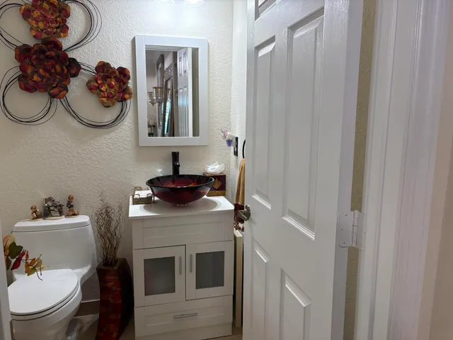 a bathroom with a sink vanity mirror and toilet