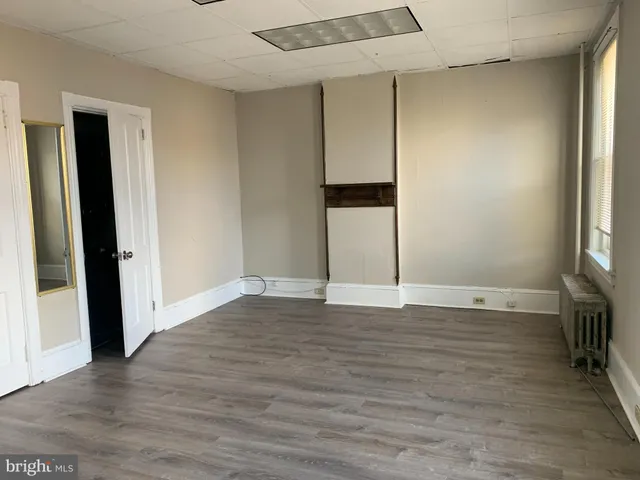 an empty room with wooden floor and a window