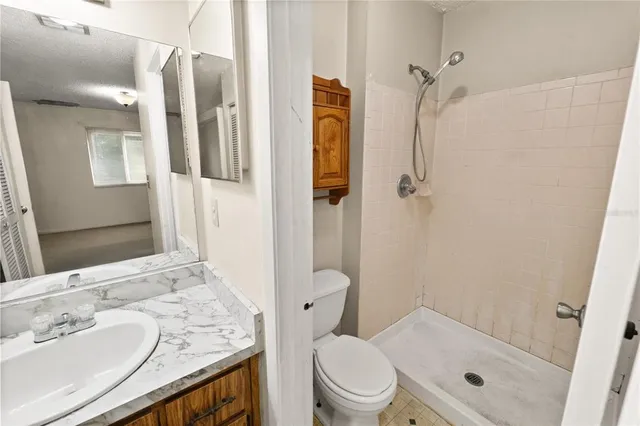 a bathroom with a granite countertop sink toilet and shower