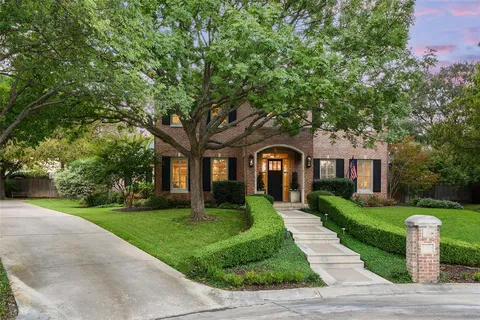 a front view of a house with yard and green space