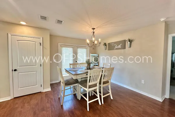 a bedroom with a bed chandelier and a window