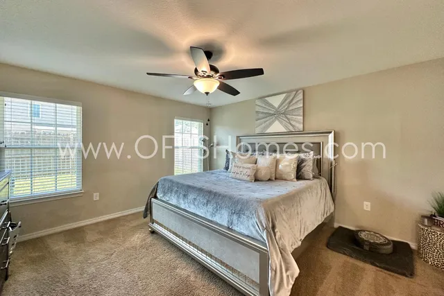 a bedroom with a bed and a ceiling fan