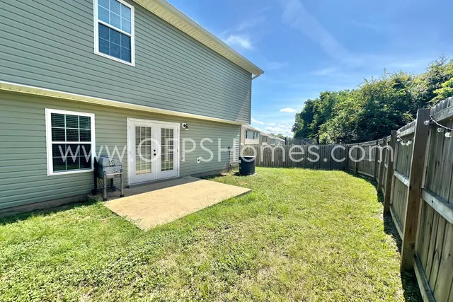 a view of a back yard with a wooden fence