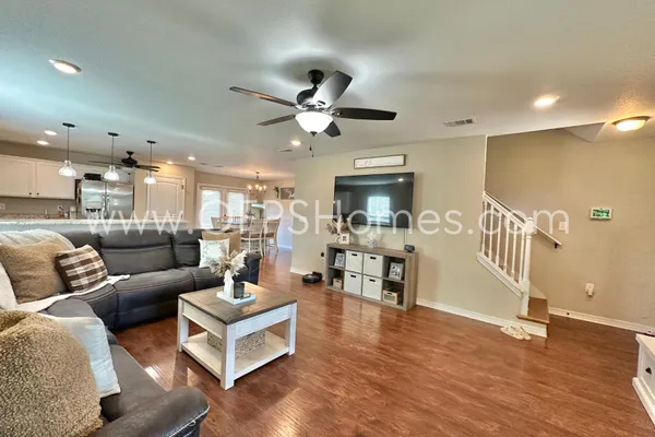 a living room with furniture and a wooden floor