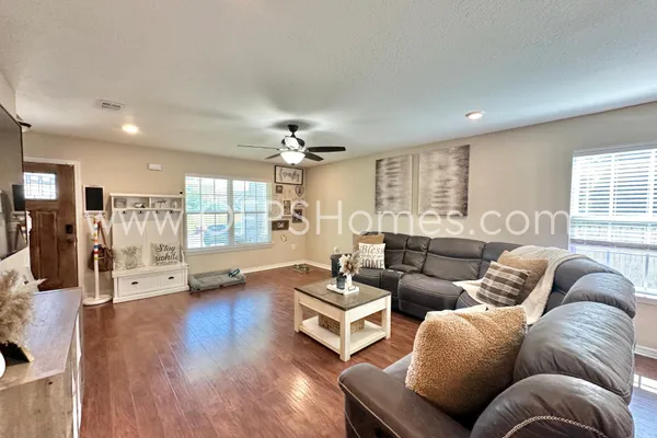 a kitchen with stainless steel appliances granite countertop a refrigerator a stove a sink dishwasher and white cabinets with wooden floor