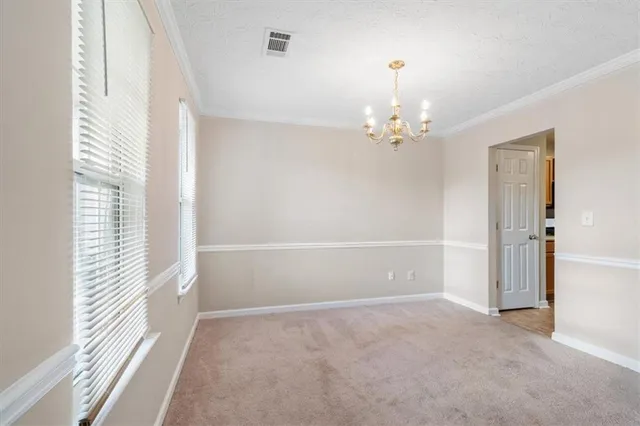 a view of a chandelier in big room and a window