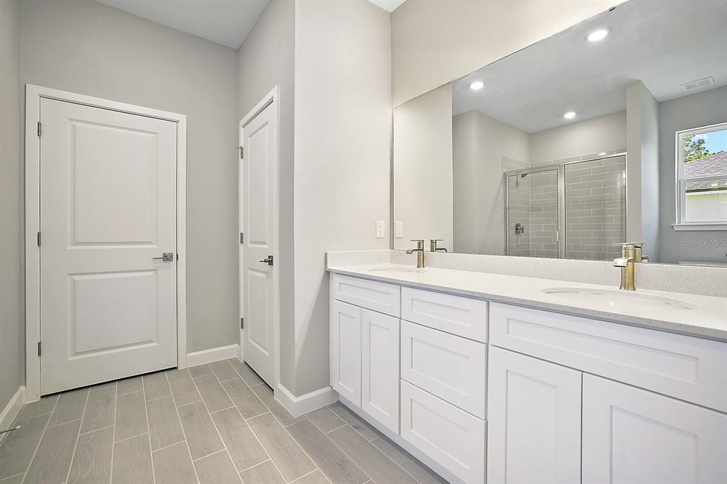 5088 Southwest 165th St Road Ocala, FL 34473 - Photo 13 of 17 a bathroom with a double vanity sink and a mirror