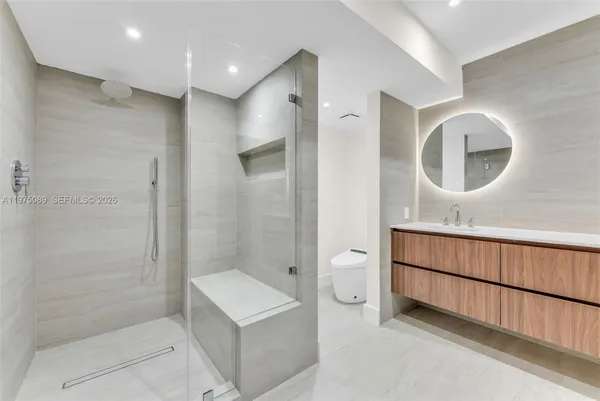 a bathroom with a glass door shower a sink and a mirror