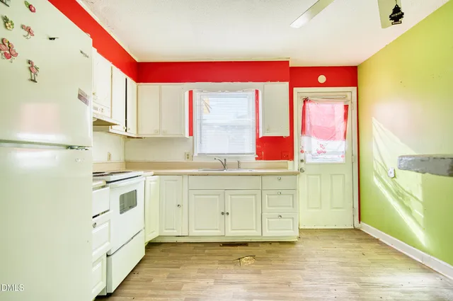 a kitchen with granite countertop white cabinets white appliances and sink