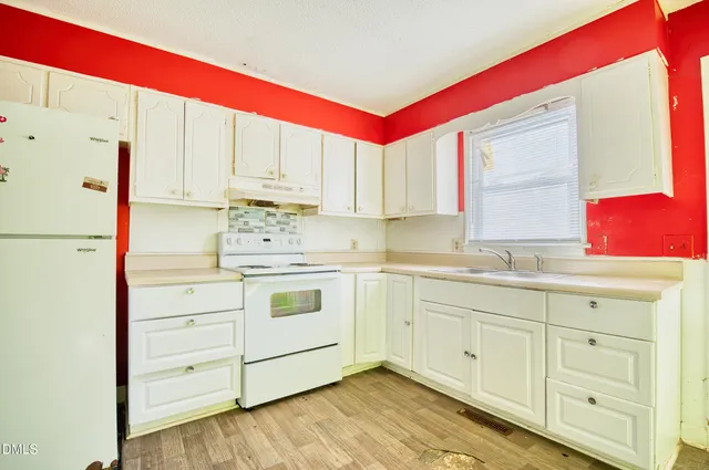 a kitchen with white cabinets and white appliances