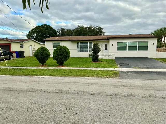 a front view of a house with a yard and a garage