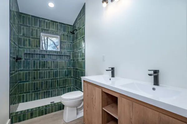 a bathroom with a sink a toilet and shower
