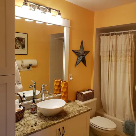 a bathroom with a granite countertop sink mirror vanity and toilet