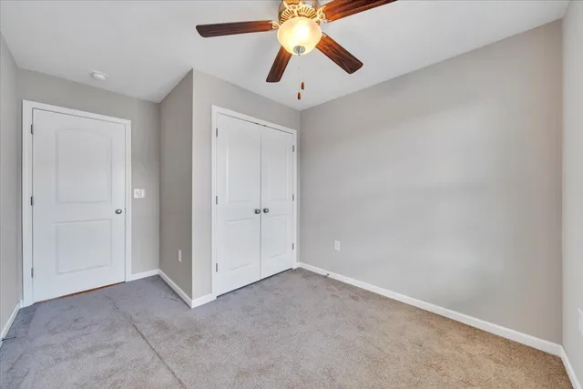 an empty room with chandelier fan
