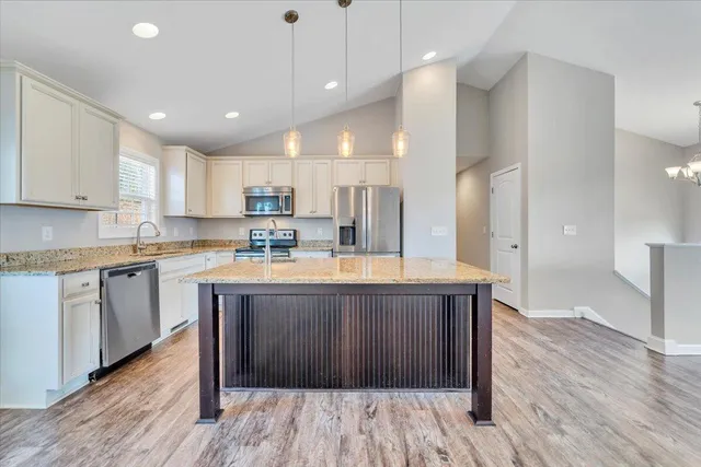 a kitchen with stainless steel appliances granite countertop wooden floors and wooden cabinets