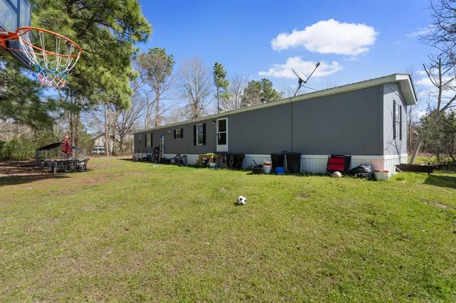 a view of a house with backyard and a tree