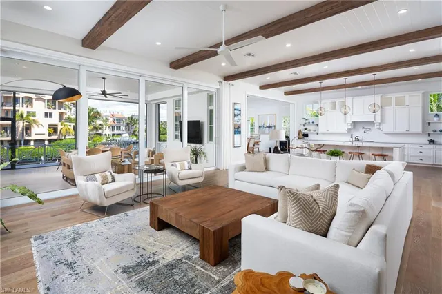 a living room with furniture wooden floor and view of kitchen
