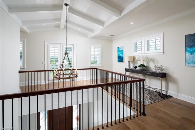 a view of a hallway with wooden floor and stairs