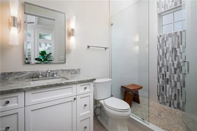 a bathroom with a granite countertop toilet sink and shower