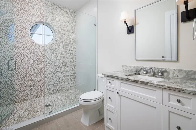 a bathroom with a granite countertop sink toilet and shower