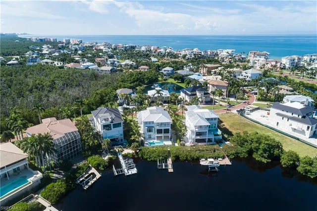 an aerial view of a city with lots of residential buildings ocean and mountain view in back