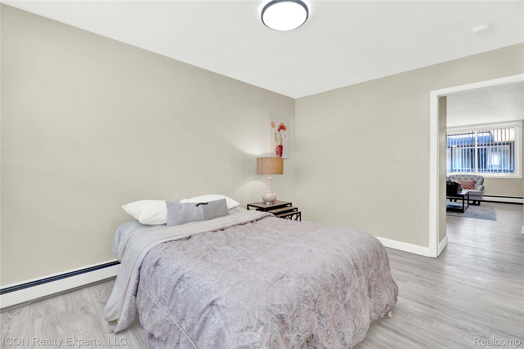 18400 Lahser Road Detroit, MI 48219 - Photo 17 of 22 Bedroom with baseboard heating, light wood-style flooring, and a baseboard heating unit