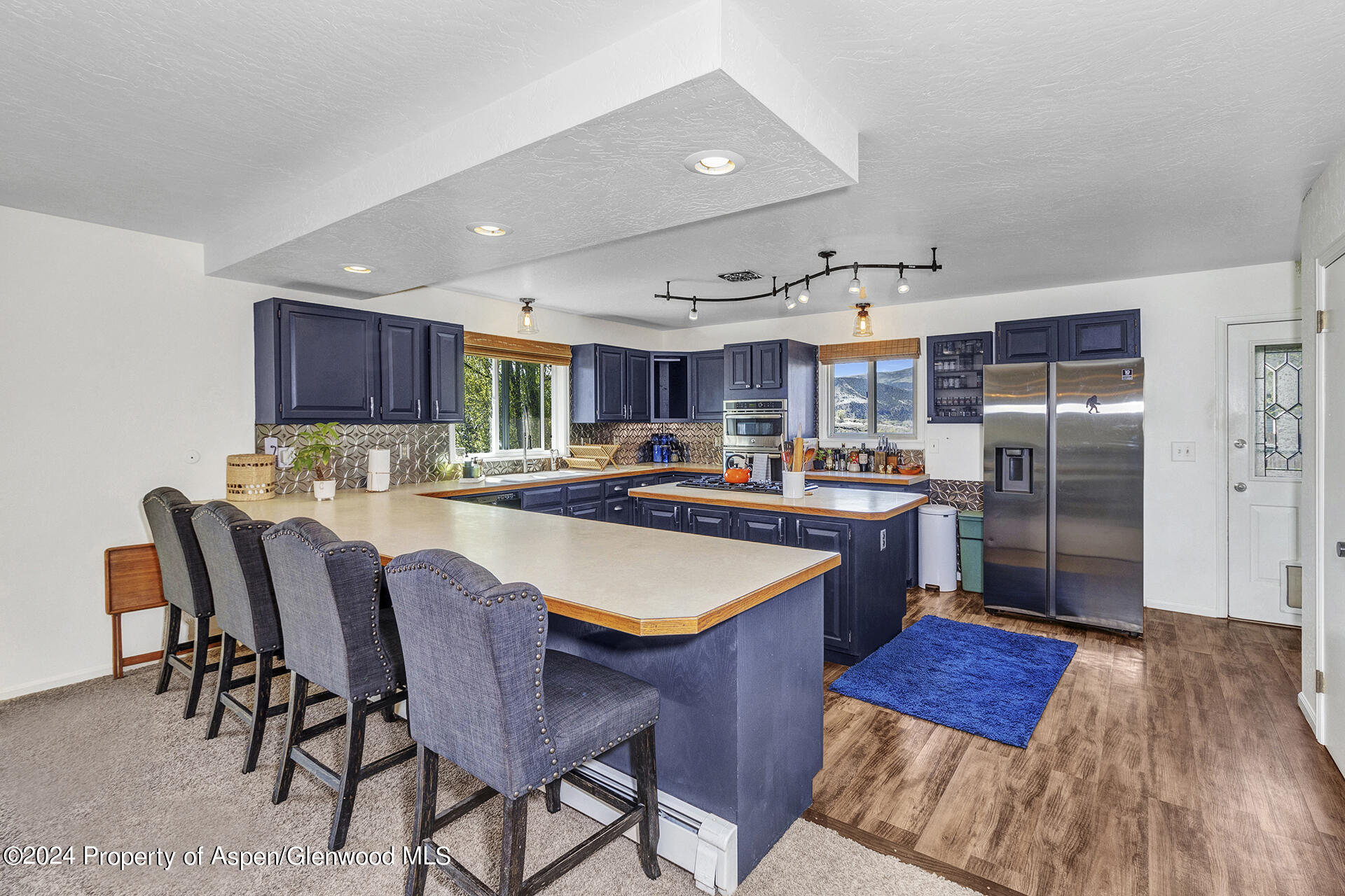 674 Mesa Court Rifle, CO 81650 - Photo 10 of 38 a kitchen with stainless steel appliances granite countertop a table chairs and a refrigerator