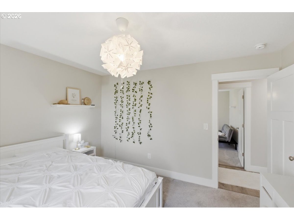 12008 Duck Inn Road Northeast Gervais, OR 97026 - Photo 32 of 48 a bedroom with a bed and a chandelier