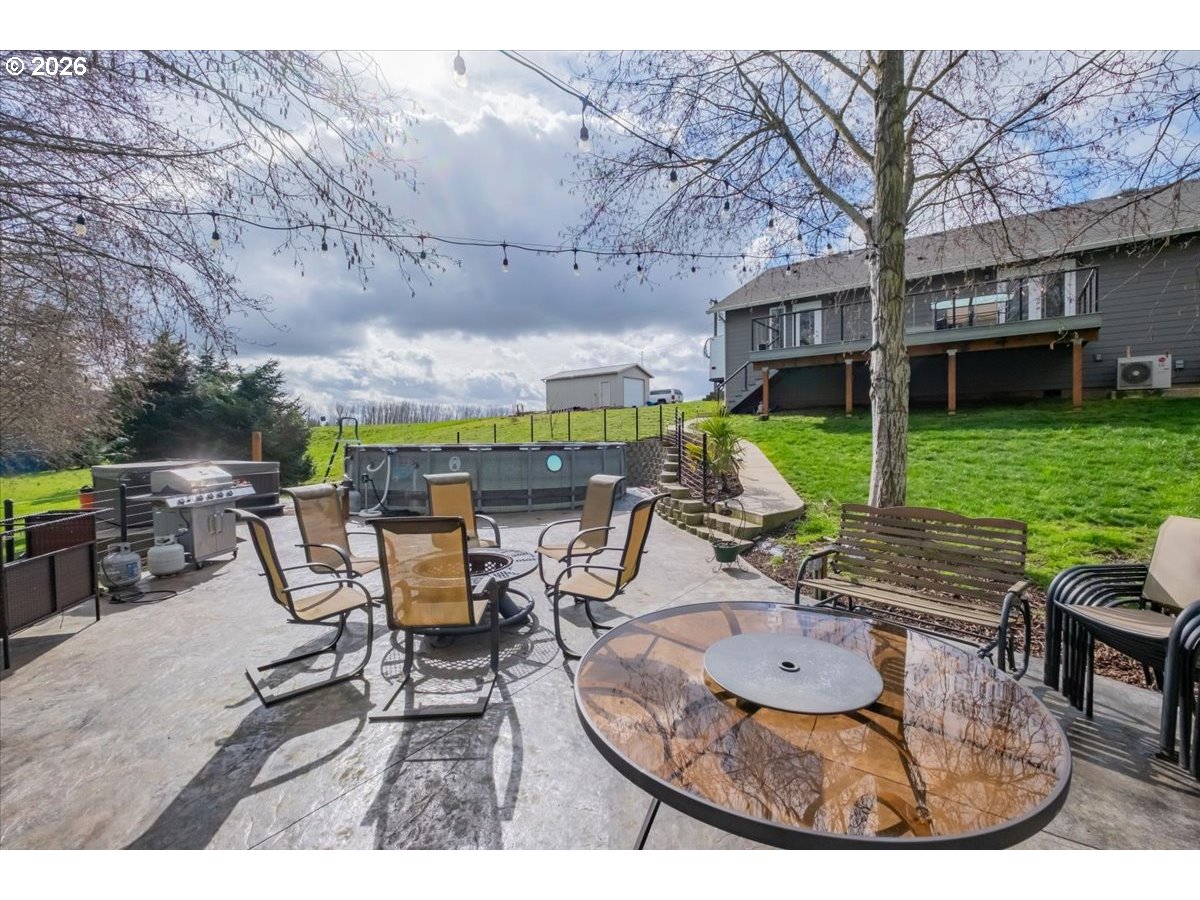 12008 Duck Inn Road Northeast Gervais, OR 97026 - Photo 42 of 48 a view of a patio with table and chairs potted plants with wooden floor and fence