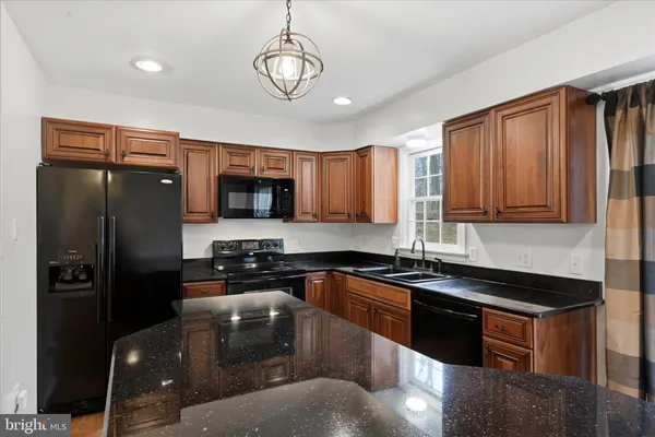 a kitchen with stainless steel appliances granite countertop a sink a stove and a refrigerator