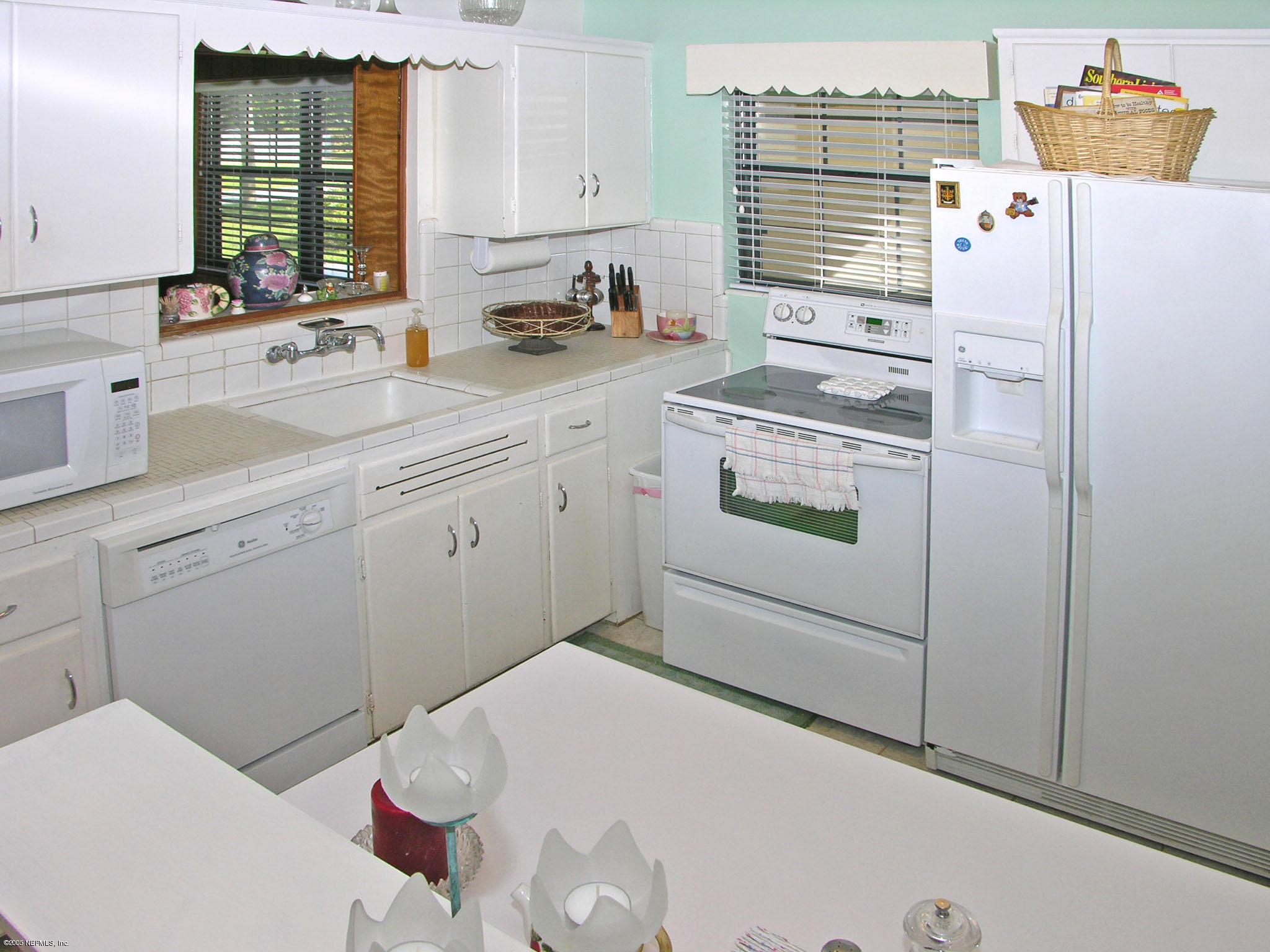 2918 Christopher Road Jacksonville, FL 32217 - Photo 3 of 10 a kitchen with a refrigerator and white cabinets