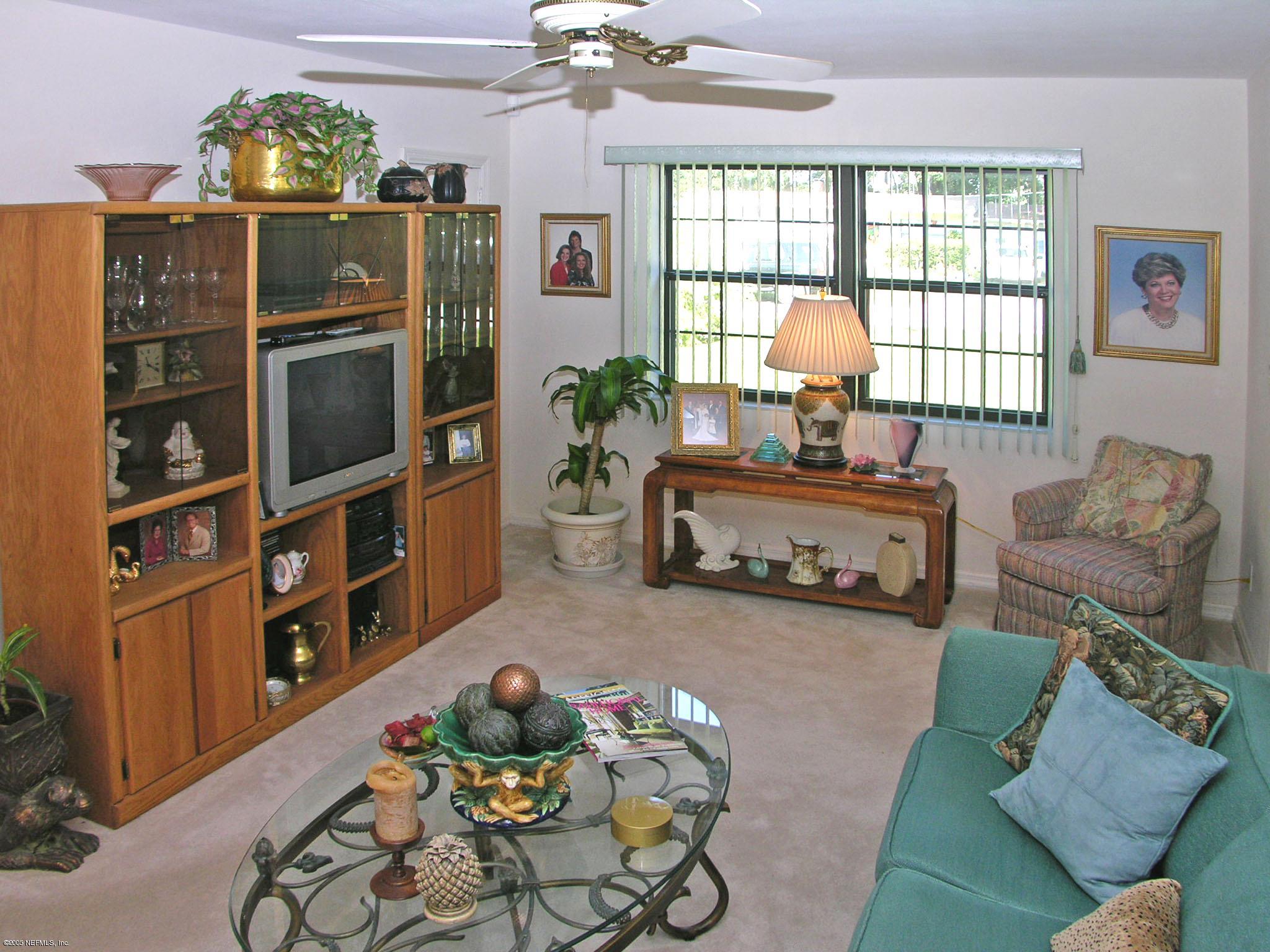 2918 Christopher Road Jacksonville, FL 32217 - Photo 4 of 10 a living room with furniture a chandelier and a flat screen tv