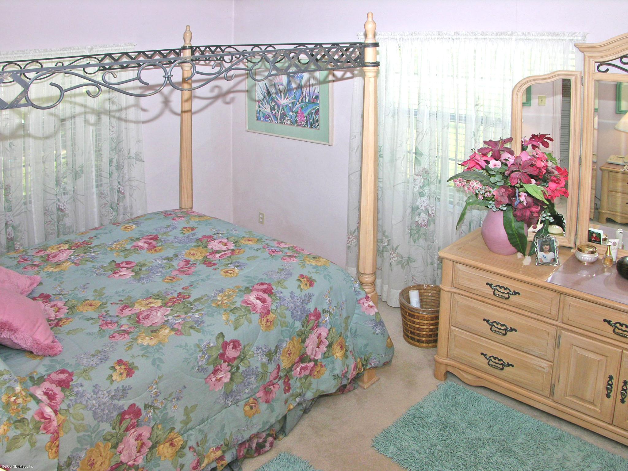2918 Christopher Road Jacksonville, FL 32217 - Photo 5 of 10 a bedroom with a bed dresser and a mirror