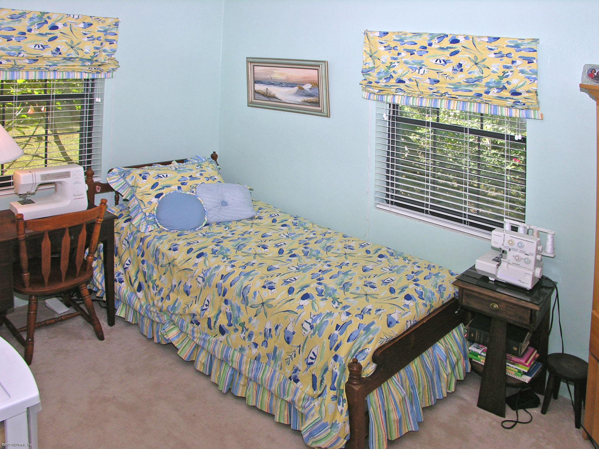 2918 Christopher Road Jacksonville, FL 32217 - Photo 8 of 10 a bedroom with a bed and a table