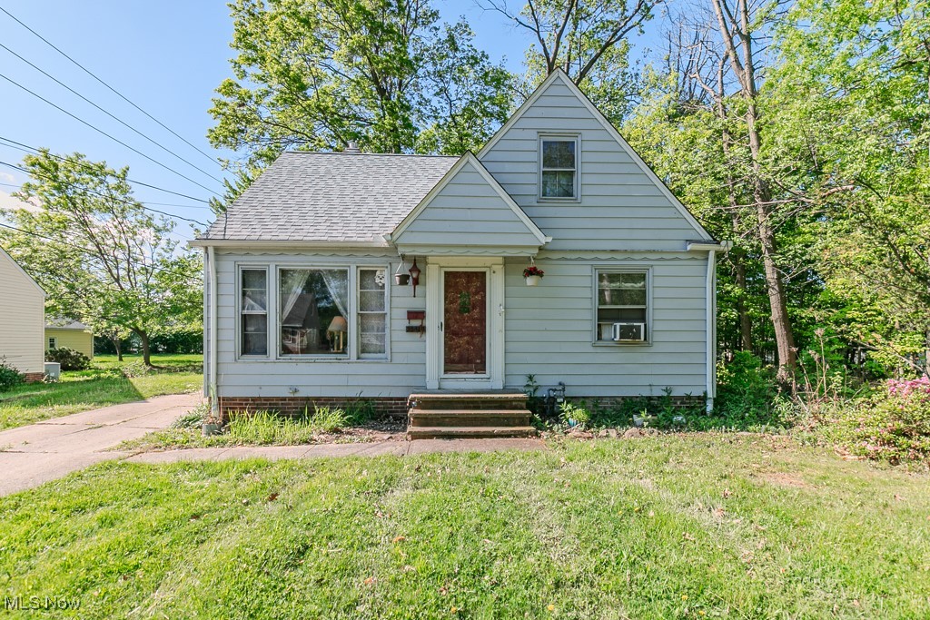Bungalow-style house featuring a front lawn, entry steps, and roof with shingles